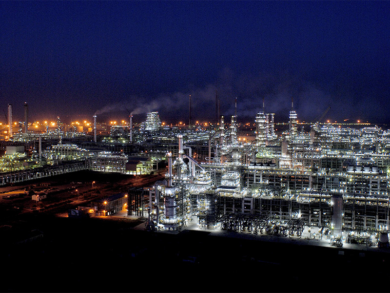 An aerial view of the vast Jamnagar refinery complex in Gujarat, India, dense with towers, pipework and storage tanks.